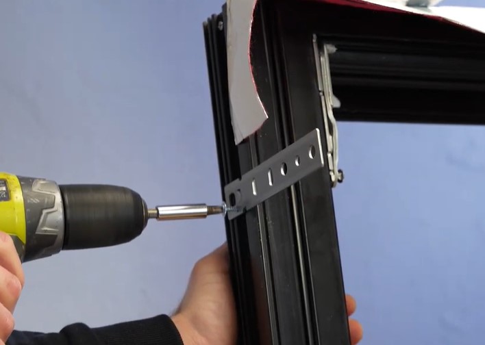screwing the strap anchors during european window installation